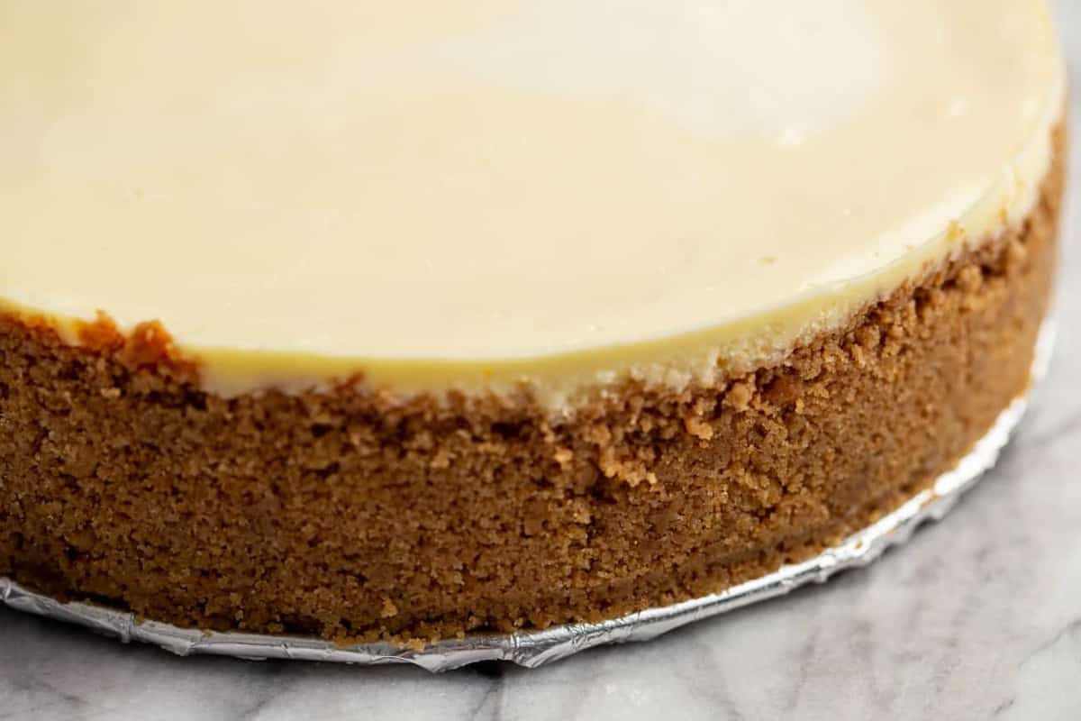 A springform pan with an even pressed graham cracker crust across the bottom and slightly up the sides